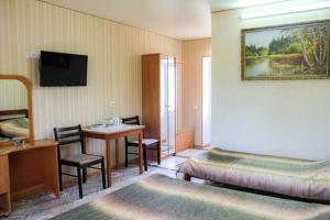 a hotel room with a bed and a desk and a table at Hotel Irina in Gribovka