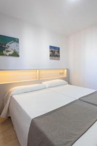 a bedroom with two beds and two pictures on the wall at Aparthotel BCL Levante Club in Benidorm