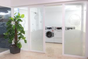 a laundry room with a washing machine and a plant at Aparthotel BCL Levante Club in Benidorm