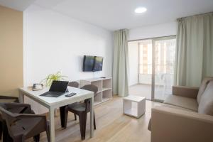 a living room with a desk with a laptop on it at Aparthotel BCL Levante Club in Benidorm