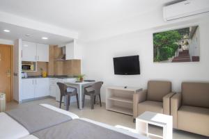 a kitchen and a living room with a table and chairs at Aparthotel BCL Levante Club in Benidorm