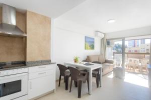 a kitchen and living room with a table and chairs at Aparthotel BCL Levante Club in Benidorm