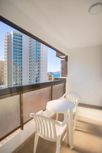 two white chairs and a table on a balcony at Aparthotel BCL Levante Club in Benidorm