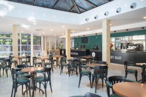 a restaurant with tables and chairs and a bar at Aparthotel BCL Levante Club in Benidorm