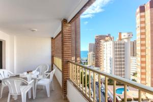 a balcony with tables and chairs and a view of the city at Aparthotel BCL Levante Club in Benidorm
