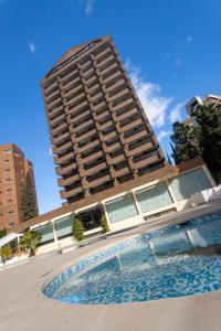 a tall building with a swimming pool in front of a building at Aparthotel BCL Levante Club in Benidorm