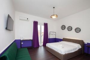 sypialnia z łóżkiem i kanapą w obiekcie Myrtus Guest House Cagliari w Cagliari