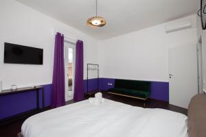 sypialnia z białym łóżkiem i zieloną kanapą w obiekcie Myrtus Guest House Cagliari w Cagliari