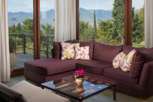 a living room with a purple couch and a glass table at Amalia Hotel Delphi in Delfoi