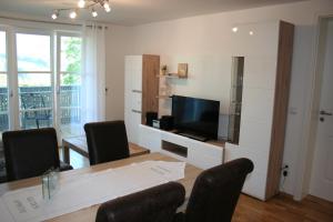 a living room with a dining room table and a television at Haus "Bergblick" Apartment mit 1 Schlafzimmer in Oberstaufen