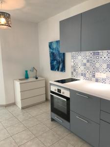 a kitchen with a stove and a counter top at Appartement classé, vue mer, clim, wifi, parking in La Grande-Motte
