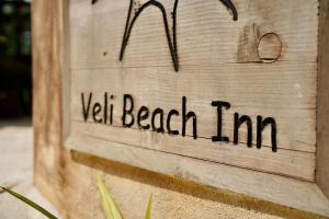 a wooden sign with the words yellow beach inn on it at Veli Beach Inn in Mathiveri