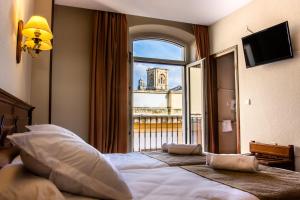 ein Hotelzimmer mit einem großen Bett mit Fenster in der Unterkunft Hotel Reina Cristina in Granada