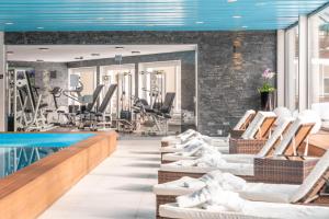 a gym with chairs and a swimming pool at Hotel Europe in Davos