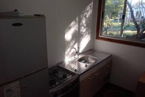 a small kitchen with a sink and a window at • Cabaña Las Hortensias • in La Pedrera