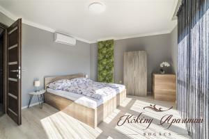 een slaapkamer met een bed in een kamer bij Kökény Apartman Bogács in Bogács