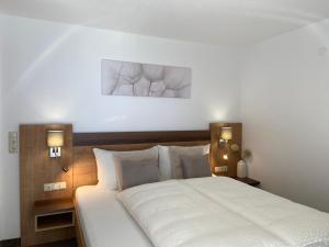 カップルにあるXenia Apartmentsのベッドルーム1室(壁に2枚の写真が飾られたベッド1台付)