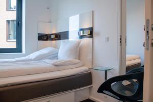 a bedroom with a white bed and white walls at Wakeup Copenhagen - Borgergade in Copenhagen