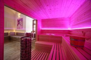 uma sauna com iluminação rosa num quarto em Schloss Fischhorn am See em Bruck an der Grossglocknerstrasse