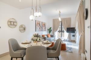 a dining room and living room with a table and chairs at Durrani Homes - State Of The Art Living At Old Town 1 Bed in Dubai