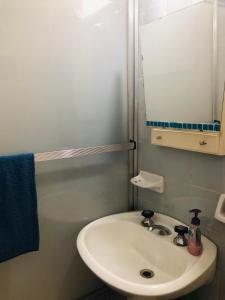 een badkamer met een witte wastafel en een spiegel bij Luminoso departamento en el corazón de Olivos in Olivos