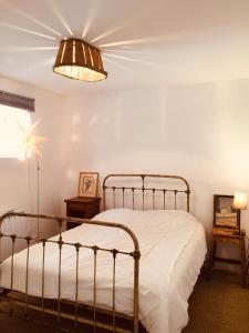 Ferme St Pierre gîte autonome 2-4 personnes في Chabeuil: غرفة نوم بسرير معدني ومصباح