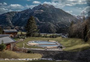 a house with a swimming pool and a mountain at Benglerwald Berg Chaletdorf in Bach