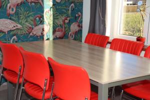 une salle de conférence avec une table et des chaises rouges dans l'établissement Juwel Fruithof, à Zepperen