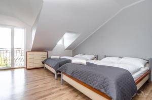two beds in a bedroom with a attic at Duży apartament Mielno in Mielno