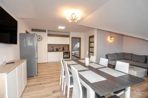 a kitchen and dining room with a table and chairs at Duży apartament Mielno in Mielno