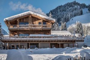 a log cabin in the snow with snow covered at Benglerwald Berg Chaletdorf in Bach