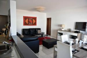 ein Wohnzimmer mit einem Sofa und einem TV in der Unterkunft Casa Franki - Stylish and large beach apartment in Algarve in Carvoeiro