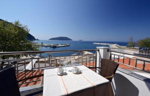 una mesa en un balcón con vistas al océano en Oasis Deluxe Apartments, en Neo Klima