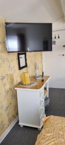 a room with a desk with a yellow object on a wall at The Weeton guesthouse in Blackpool