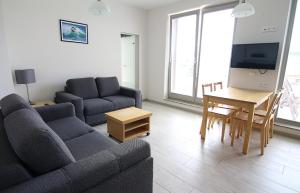 uma sala de estar com um sofá e uma mesa em Apartamenty Świnoujście - Zacisze Leśne em Świnoujście