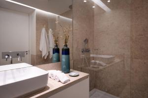 a bathroom with a sink and a shower with two bottles at Once Upon Lisboa Family Units in Lisbon +8 photos