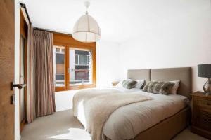 a bedroom with a large bed and a window at Sonnegg Lodge 2-2 in Saas-Fee