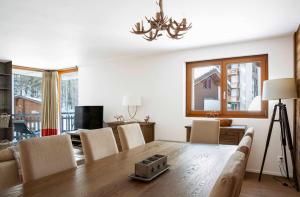 a living room with a dining room table with chairs at Sonnegg Lodge 2-2 in Saas-Fee