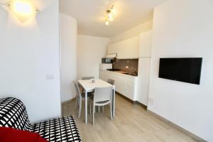 a small living room with a table and a kitchen at Gabbiano 5 in San Vincenzo +8 photos