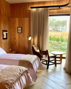a bedroom with two beds and a table and a window at Rizoma in José Ignacio