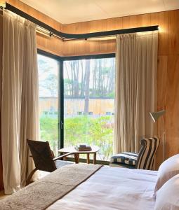 a bedroom with a bed and a large window at Rizoma in José Ignacio