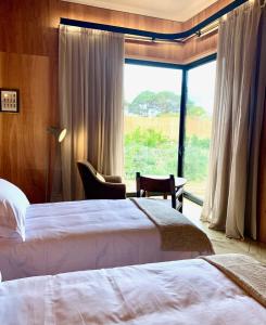 a hotel room with two beds and a large window at Rizoma in José Ignacio