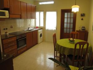 a kitchen with a table with a green table cloth at Casa Nuno e Lorena - Casa completa e Localização ideal in Ponta Delgada