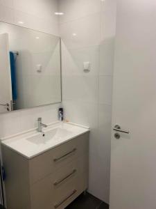 a bathroom with a sink and a mirror at Casa do Chinelo Azul in Queluz