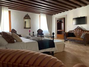 ein Schlafzimmer mit 2 Betten, einem Sofa und einem TV in der Unterkunft Riva De Biasio in Venedig