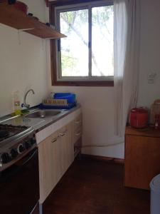 a kitchen with a sink and a stove and a window at • Cabaña Las Hortensias • in La Pedrera