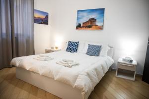 - une chambre avec un lit blanc et 2 serviettes dans l'établissement Il Moro - Agrigento Rooms, à Favara