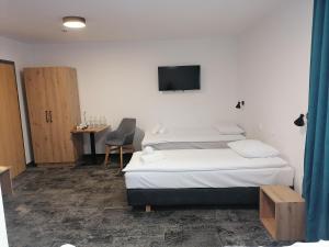 a bedroom with a bed and a tv on the wall at Pokoje Hotelowe LUPUS in Gołdap