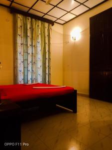 a red bed in a room with a window at Country Side Inn Portuguese Guest House in Cuelim