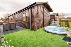 a small house with a hot tub in a yard at La-Serenite Lodge With Hot Tub in Malton